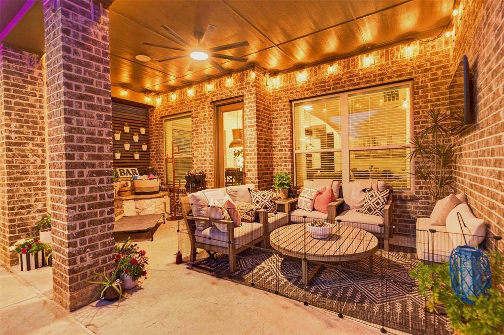 Covered outdoor living area with a fireplace and space for year-round gatherings.