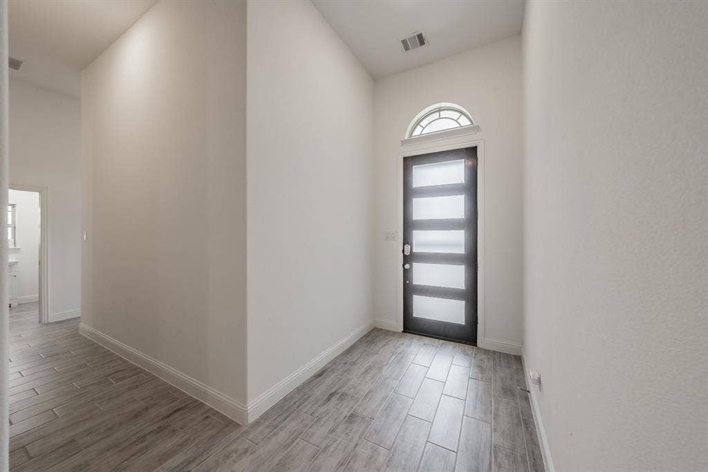 Foyer entrance featuring tile wood-style floors and contemporary front door lets in all the sunshine without the heat!