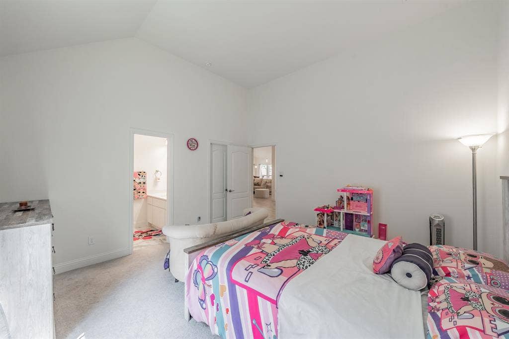 Carpeted bedroom with lofted ceiling and ensuite bathroom