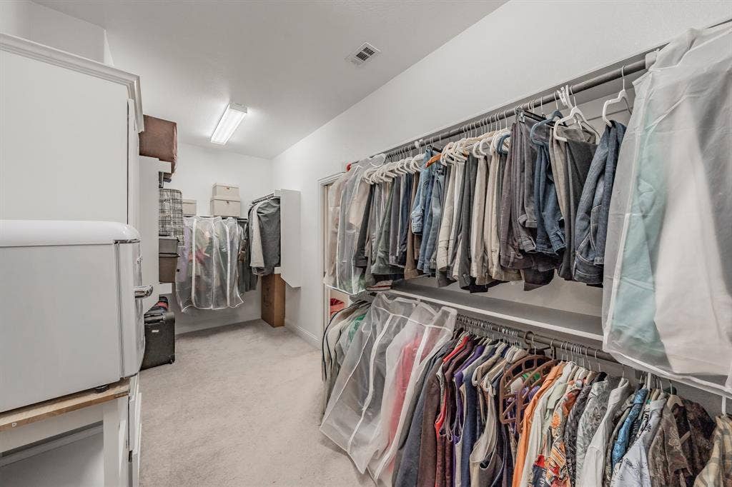 Spacious closet featuring light colored carpet