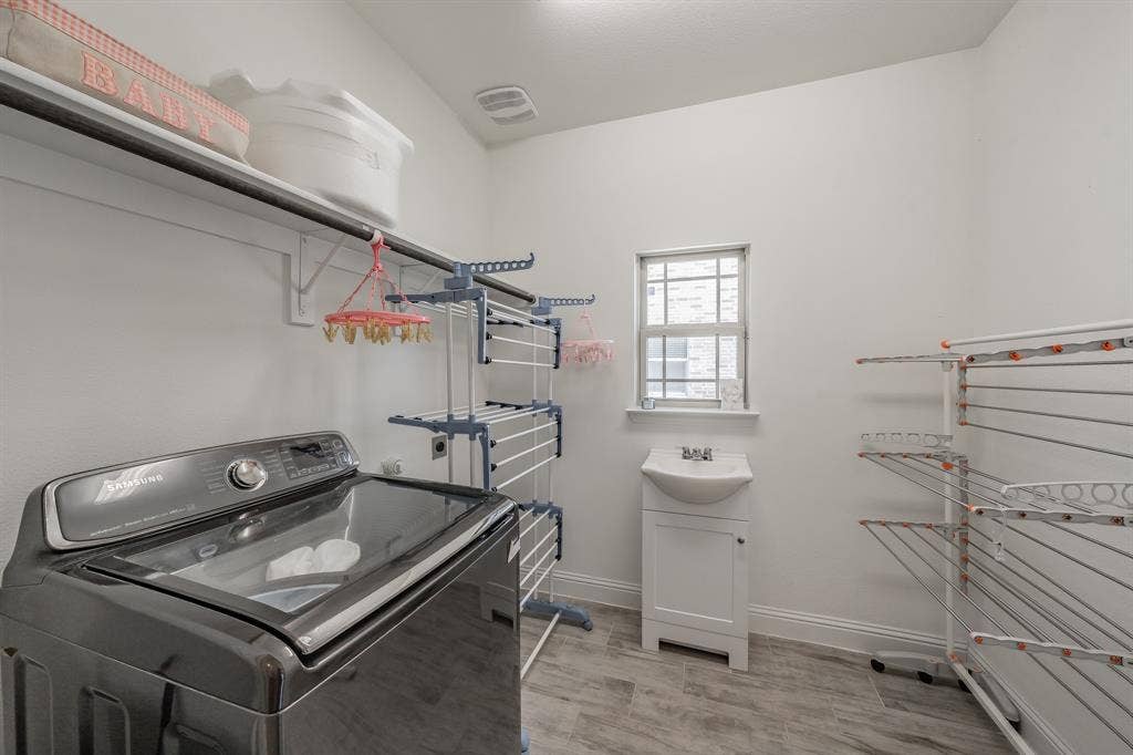 Laundry room has a sink and plenty of room for a freezer or extra fridge.