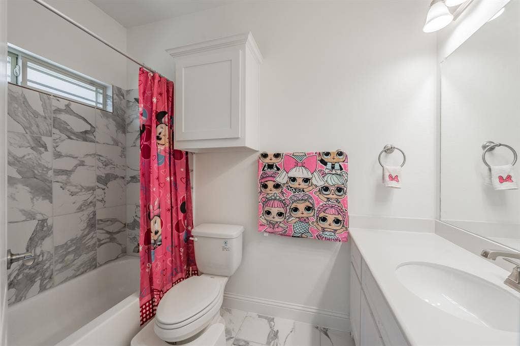 Full bathroom featuring toilet, shower / tub combo and vanity