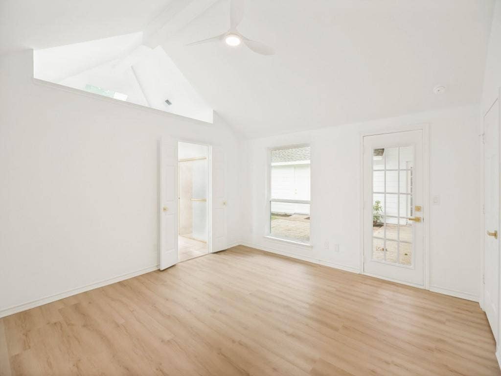 4312 Avonshire Lane, Plano, TX 75093 Vaulted ceilings with an architectural accent opening, wood-finish flooring, a ceiling fan, and a glass-paneled exterior door