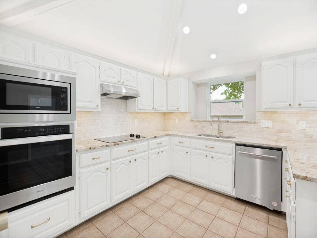 4312 Avonshire Lane, Plano, TX 75093 Kitchen featuring white cabinetry, granite countertops, tile backsplash, built-in stainless steel appliances, and recessed lighting