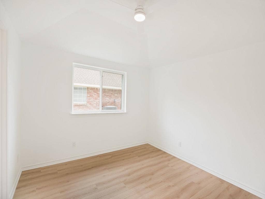 4312 Avonshire Lane, Plano, TX 75093 Room featuring neutral wall finishes, a single-pane window, wood-finish flooring, a white baseboard, and a flush-mount ceiling light