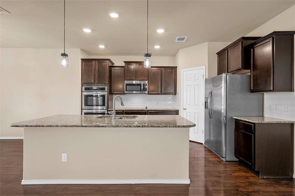 Kitchen island with a granite-style countertop and undermount sink