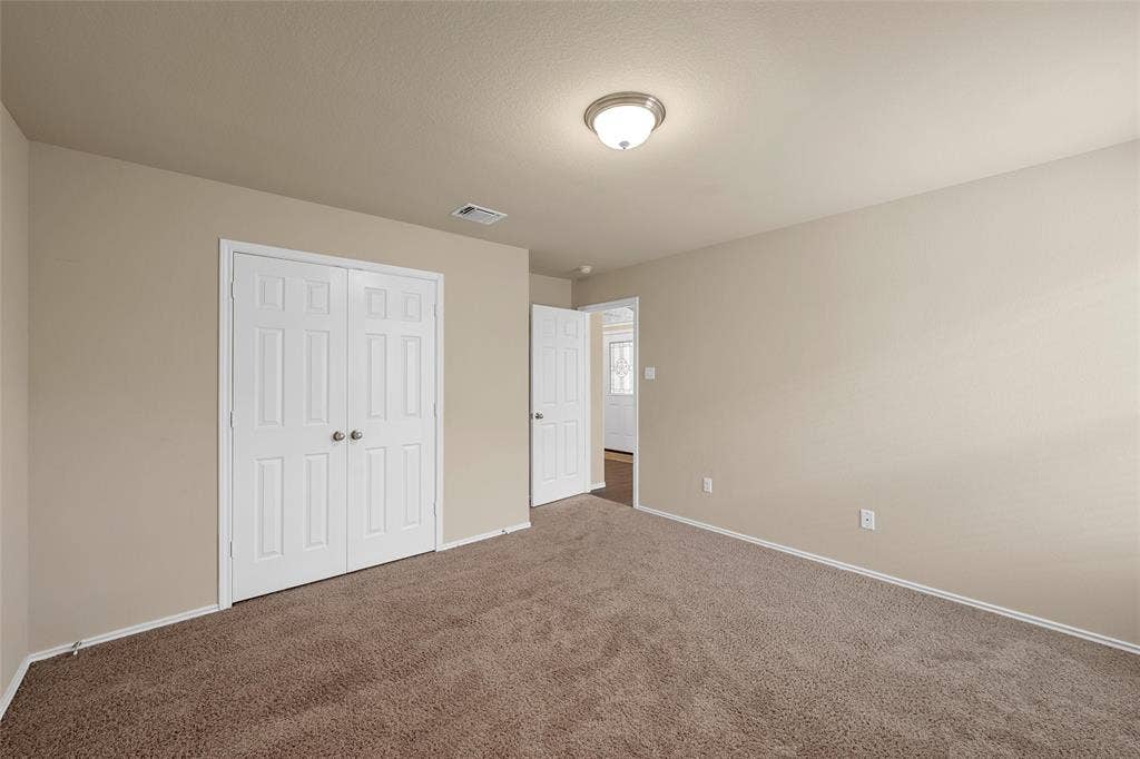 Bedroom featuring plush brown carpeting and neutral wall tones