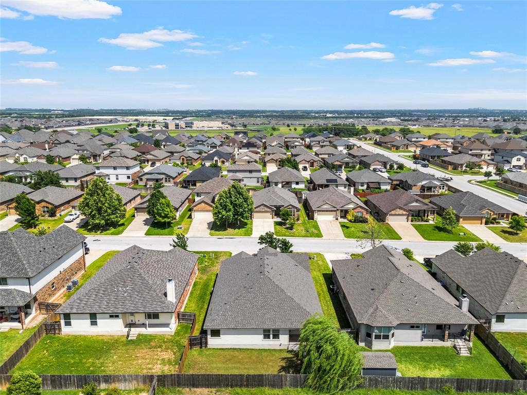 Residential neighborhood featuring a consistent architectural style, mature trees, and individual fenced backyards