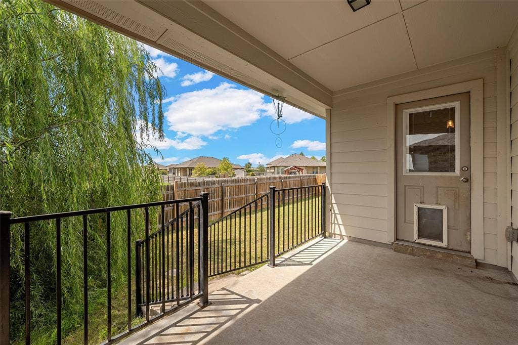 Covered patio featuring a concrete slab and a black metal railing