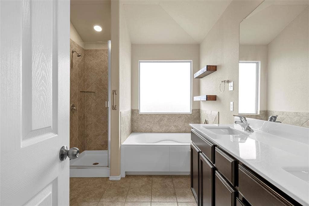 Bathroom featuring a dual vanity with white countertops, dark wood cabinetry, and chrome fixtures