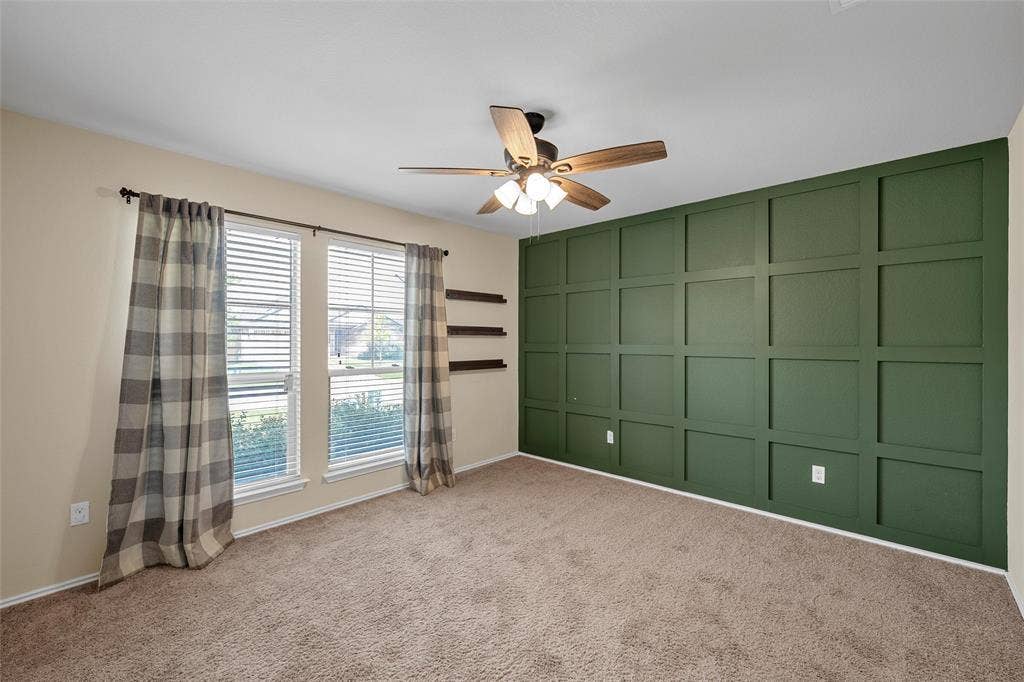 Accent wall featuring geometric paneling in a deep green hue