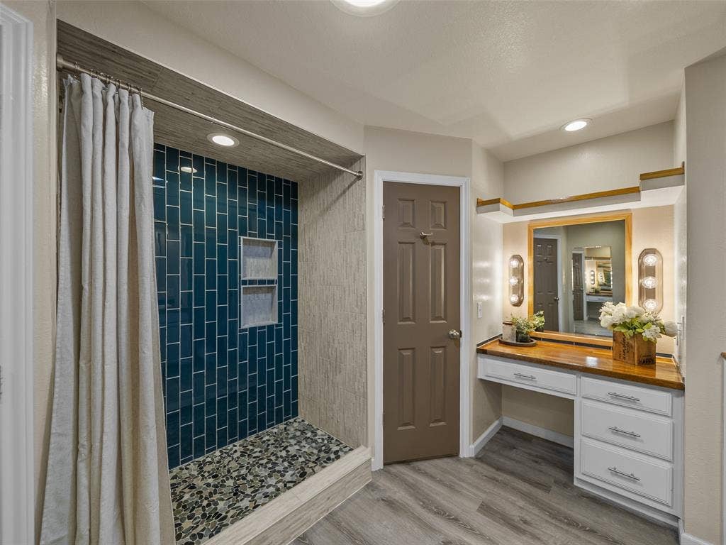 4100 Emerson Drive, Plano, TX 75093 The oversized shower has built in shelving and showcases a river rock floor.