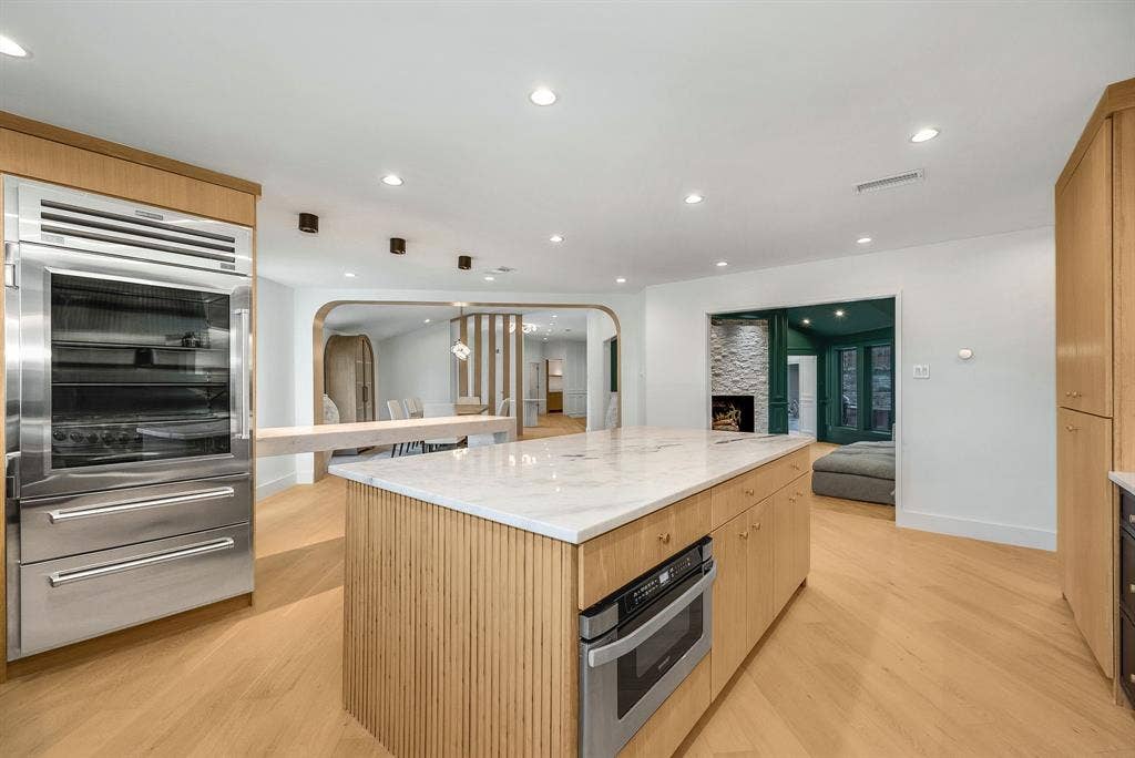 6275 Preston Creek Drive, Dallas, TX 75240 Kitchen featuring stainless steel appliances, light brown cabinetry, recessed lighting, a large island, and open floor plan