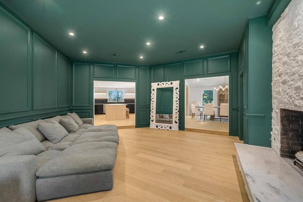 6275 Preston Creek Drive, Dallas, TX 75240 Living area featuring a decorative wall, a stone fireplace, light wood-style flooring, recessed lighting, and a chandelier