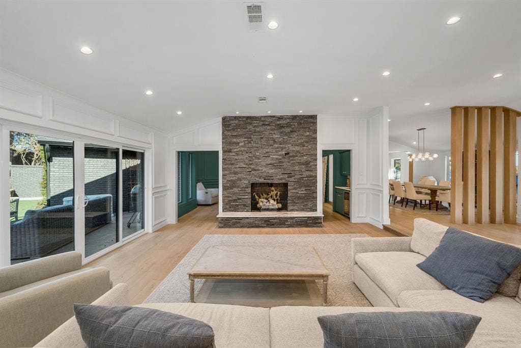 6275 Preston Creek Drive, Dallas, TX 75240 Living area featuring a stone fireplace, a decorative wall, lofted ceiling, light wood-style flooring, and recessed lighting