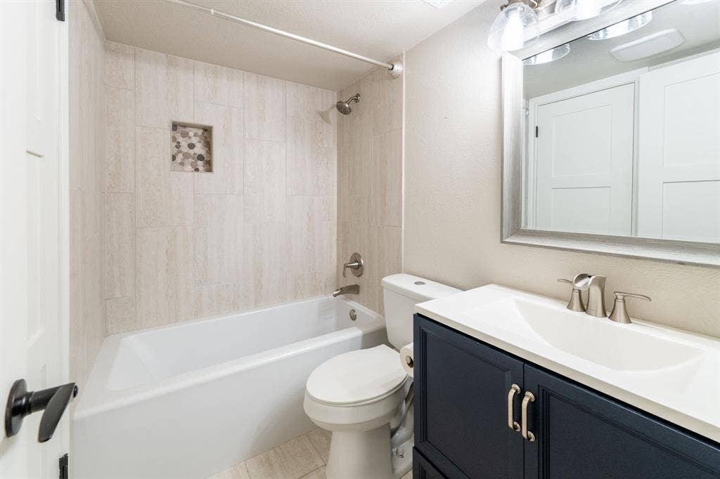 300 Rush Creek Drive, #A2, Heath, TX 75032 Bathroom featuring a shower-over-tub combination with light-toned tile surround and a recessed niche