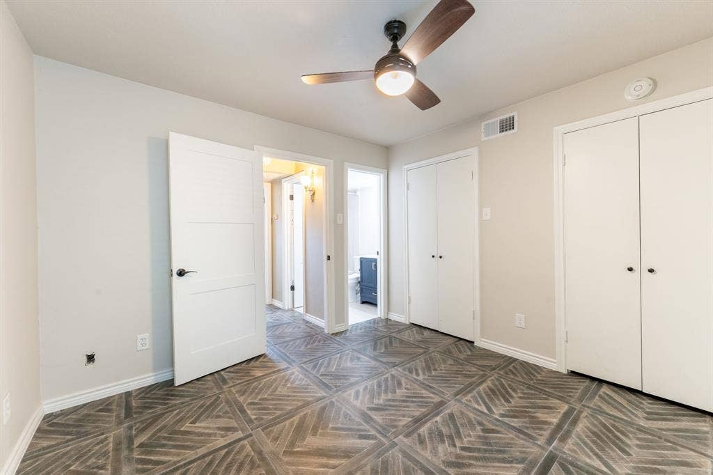 300 Rush Creek Drive, #A2, Heath, TX 75032 Room featuring a ceiling fan with integrated lighting, wood-finish flooring with a geometric pattern, and neutral-toned walls