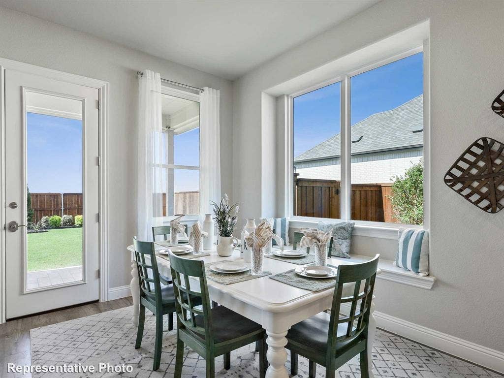 Well-lit dining area featuring a window seat, white trim, and wood-finish flooring