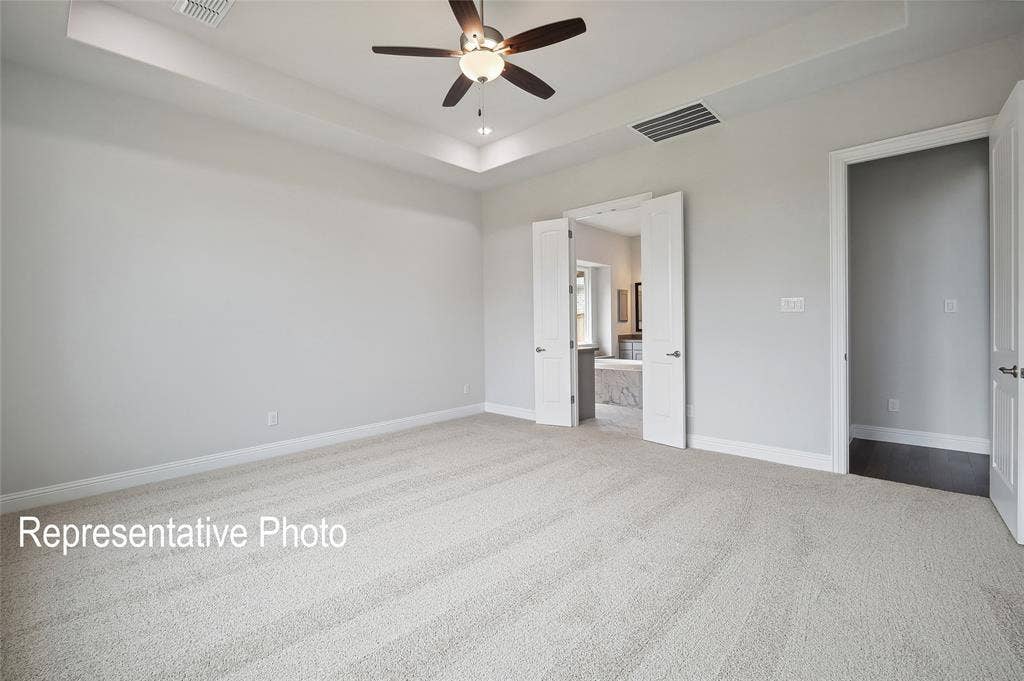 2297 Slate Drive, Waxahachie, TX 75167 Spacious carpeted room featuring a tray ceiling with recessed lighting and a ceiling fan