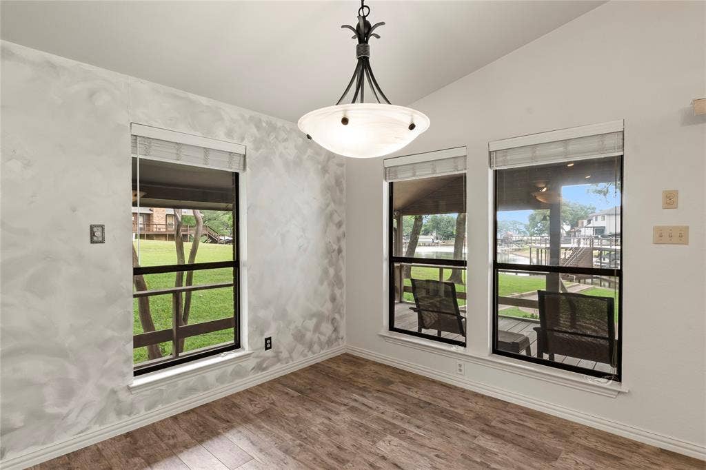 1524 Villa Cove Drive, Tool, TX 75143 Open-concept living space with wood-grain porcelain tile, flowing seamlessly from kitchen to dining—perfect for entertaining or relaxing with lake views.