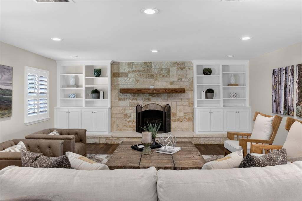 690 Orchid Hill Lane, Copper Canyon, TX 76226 Another view of living area featuring the beautifully appointed built-in book shelves and a wood burning fireplace