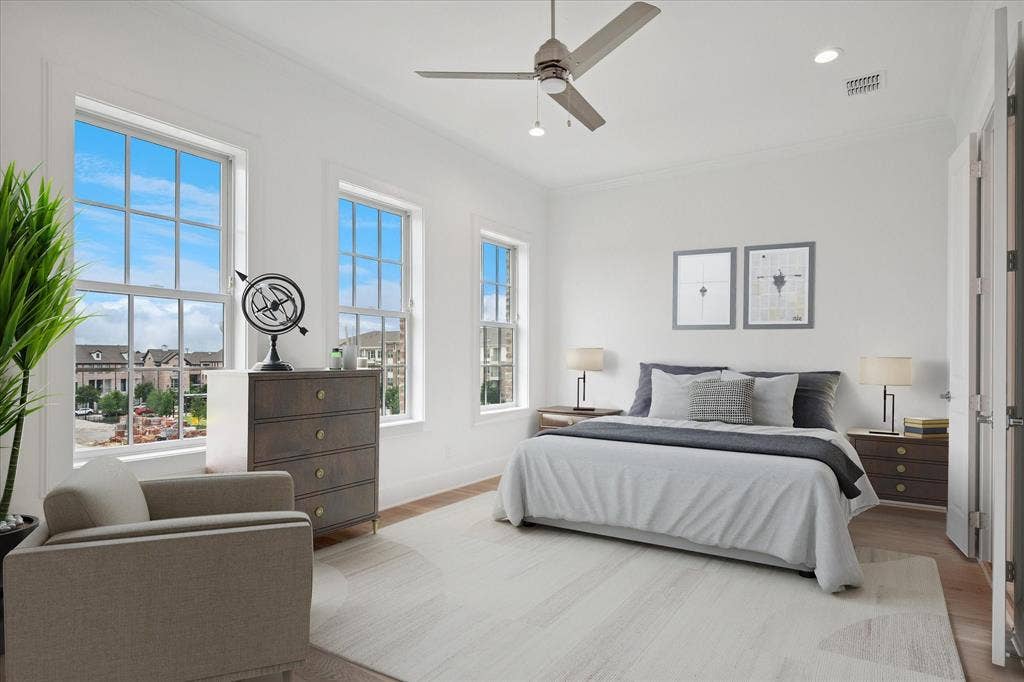 Bright interior space featuring multiple grid-pattern windows, wood-finish flooring, recessed lighting, and a ceiling fan