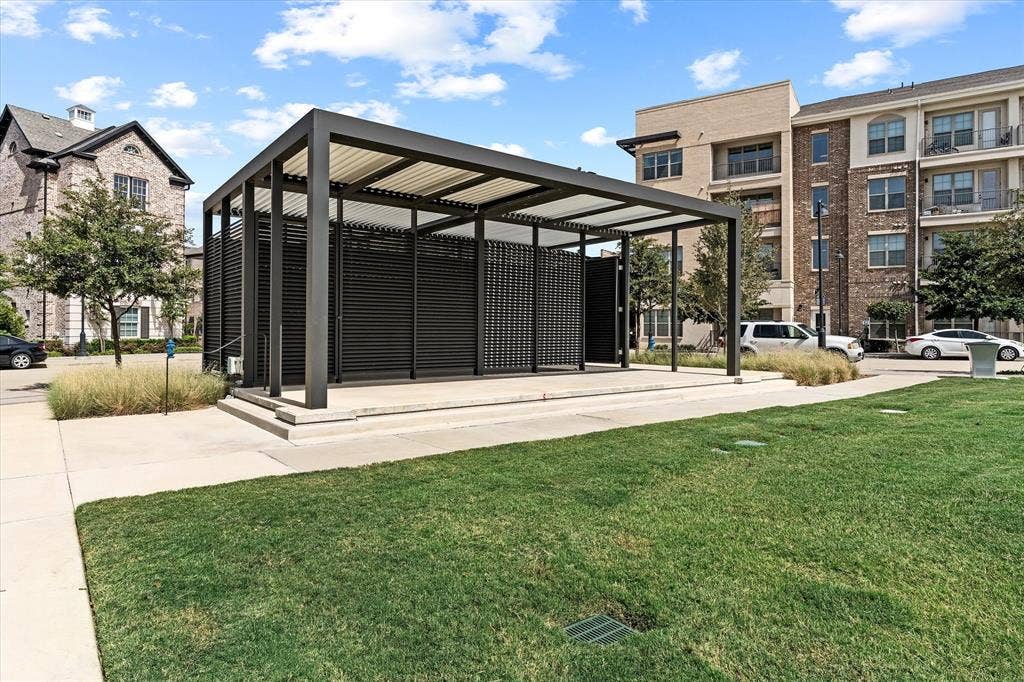 Modern outdoor pavilion with slatted privacy screens, a slatted roof, and an elevated concrete platform