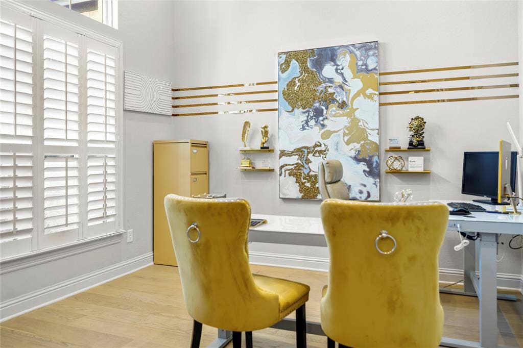Dedicated home office featuring hardwood floors, plantation shutters and abundant natural light."