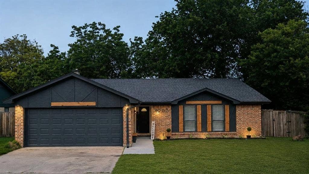 1205 Augusta Road, Benbrook, TX 76126 Brick exterior with dark gray siding accents and a coordinating garage door