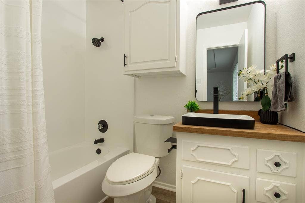 1205 Augusta Road, Benbrook, TX 76126 Bathroom vanity with a wood-finish countertop, vessel sink, and matte black fixtures