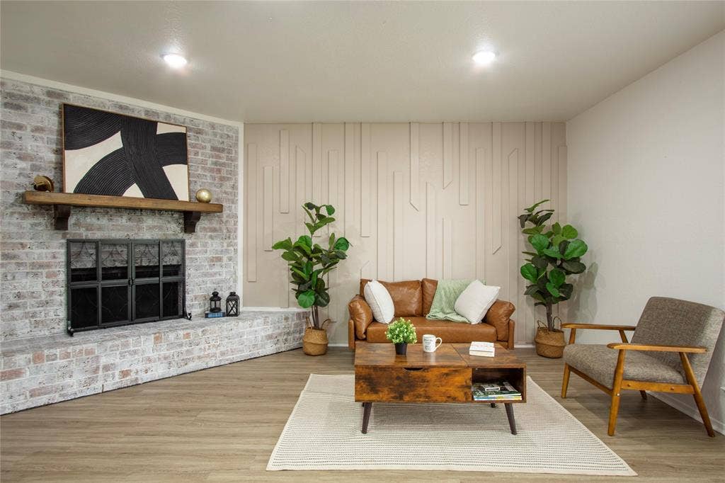 1205 Augusta Road, Benbrook, TX 76126 Living space featuring a whitewashed brick fireplace with a wood mantle, wood-finish flooring, recessed lighting, and a textured accent wall