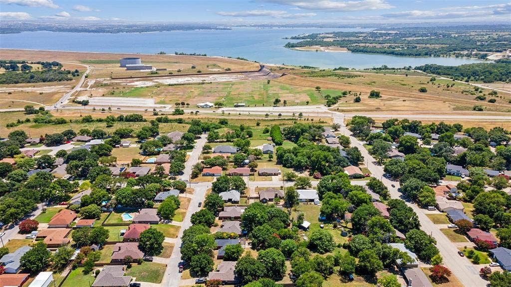 1205 Augusta Road, Benbrook, TX 76126 Established residential area featuring mature tree-lined streets and individual homes with varying architectural styles lake in sight