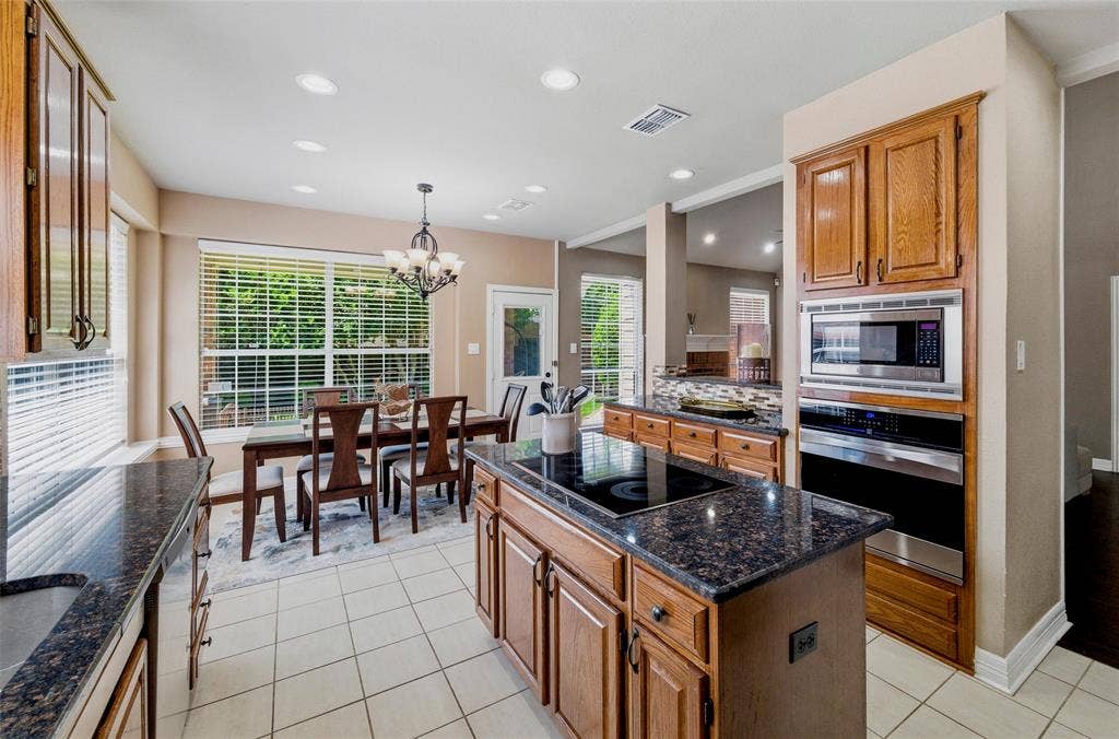 1432 Honey Locust Drive, Plano, TX 75023 Island has smooth cooktop, stainless steel built in microwave and wall oven.