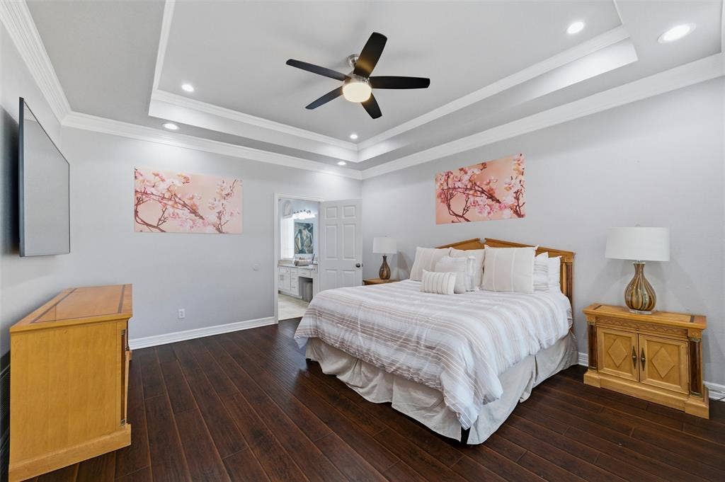 1432 Honey Locust Drive, Plano, TX 75023 Primary Bedroom with engineered wood, ceiling fan, tray ceiling with crown molding, and recessed lighting.