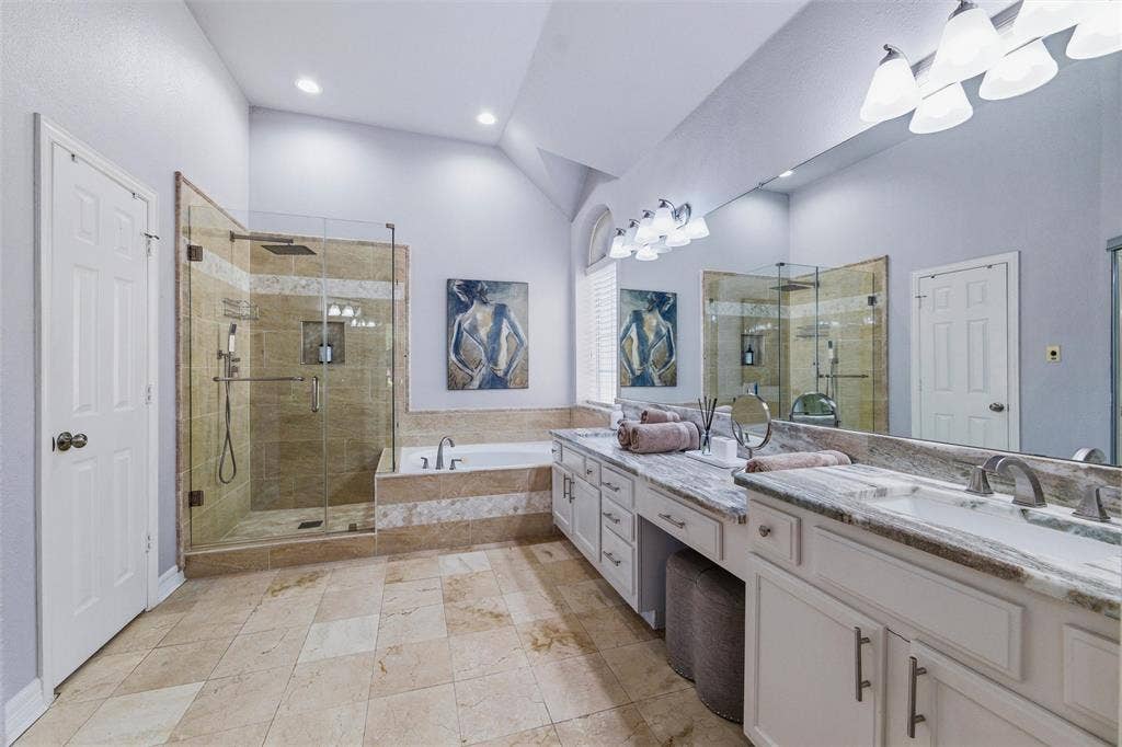 1432 Honey Locust Drive, Plano, TX 75023 Updated ensuite bath features marble floors, shower surround, and counters, seamless glass, and bidet. Dual vanities, jetted tub, and all updated fixtures including rain head with handheld shower faucets.