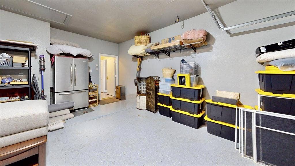 1432 Honey Locust Drive, Plano, TX 75023 Garage has recent garage door replacement, epoxy finish, walls and ceiling paint, Tesla charger, and wall rack storage system.