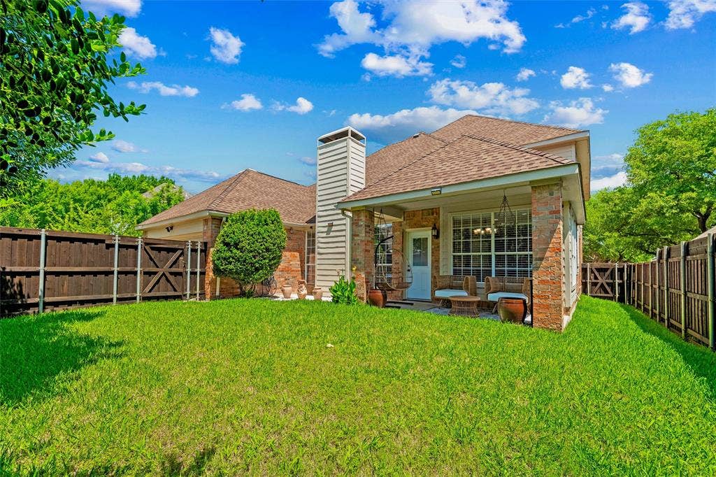 1432 Honey Locust Drive, Plano, TX 75023 Covered patio, mature landscaping, recently stained board on board fence with steel poles.