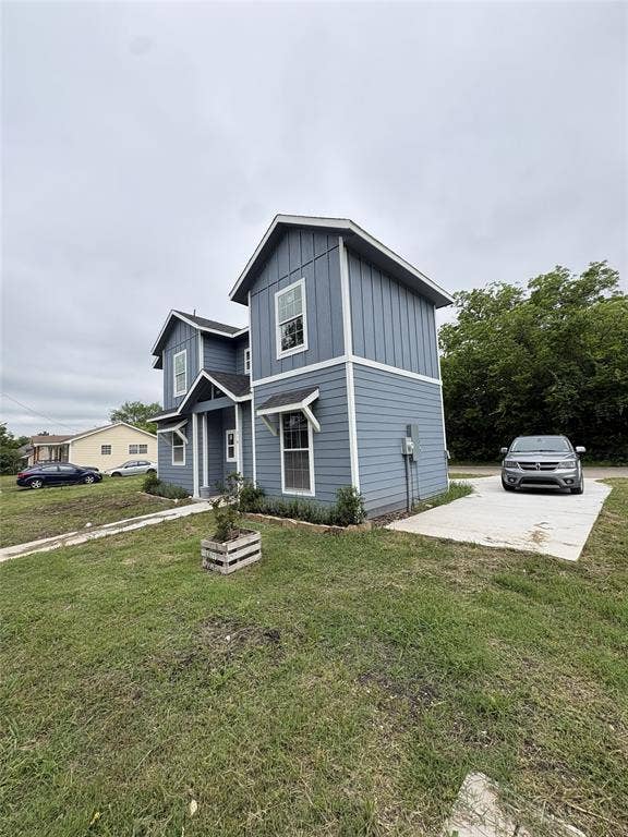 316 Henry Street, Waxahachie, TX 75165 Contemporary two-story residence featuring light blue horizontal siding and vertical board and batten accents