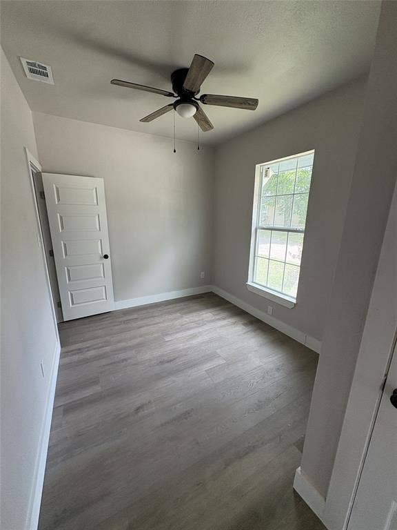 316 Henry Street, Waxahachie, TX 75165 Neutral-toned interior featuring wood-finish flooring, a ceiling fan with light, and a paneled door