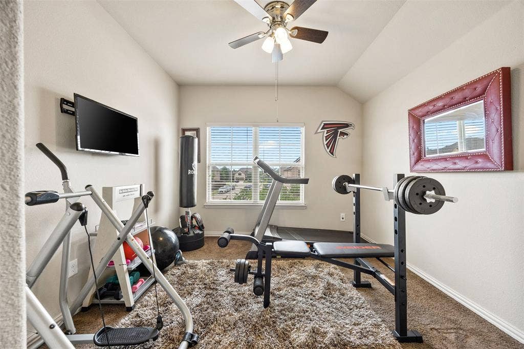 1437 Tanglewood Trail, Northlake, TX 76226 Versatile bonus room featuring a window with blinds, ceiling fan with integrated lighting, wall-mounted television bracket, and recessed wall mirror