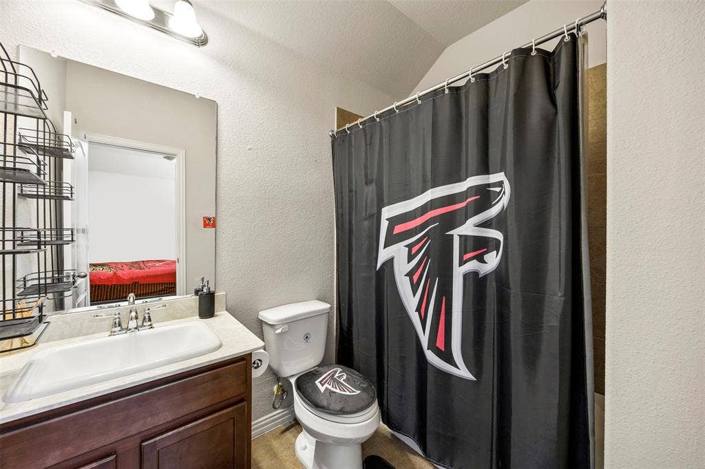 1437 Tanglewood Trail, Northlake, TX 76226 Bathroom featuring a dark wood-finish vanity with an integrated sink, polished chrome faucet, and overhead bar lighting