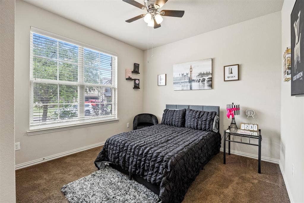 1437 Tanglewood Trail, Northlake, TX 76226 Carpeted room featuring a large multi-pane window with blinds, a ceiling fan with integrated lighting, and a neutral wall color