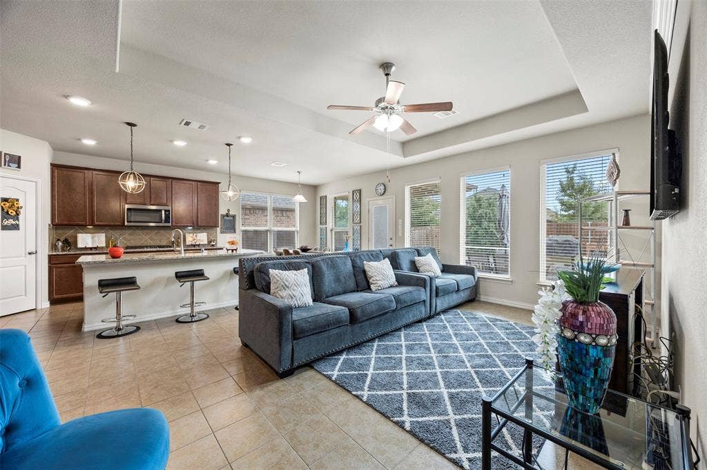 1437 Tanglewood Trail, Northlake, TX 76226 Open-concept living area featuring tile flooring, a tray ceiling, and multiple windows