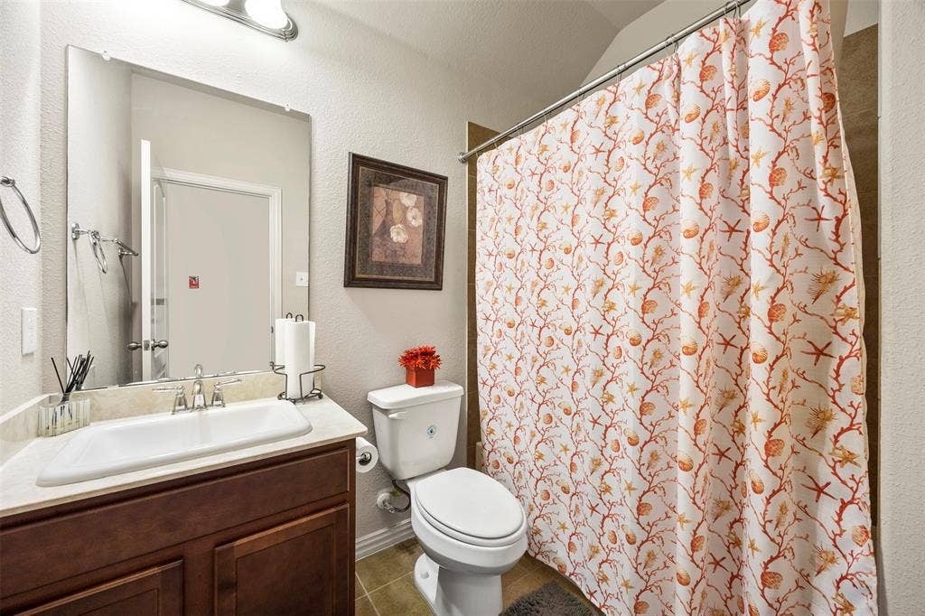 1437 Tanglewood Trail, Northlake, TX 76226 Bathroom featuring a single vanity with a white rectangular sink, a polished chrome faucet, a large frameless mirror, and a toilet