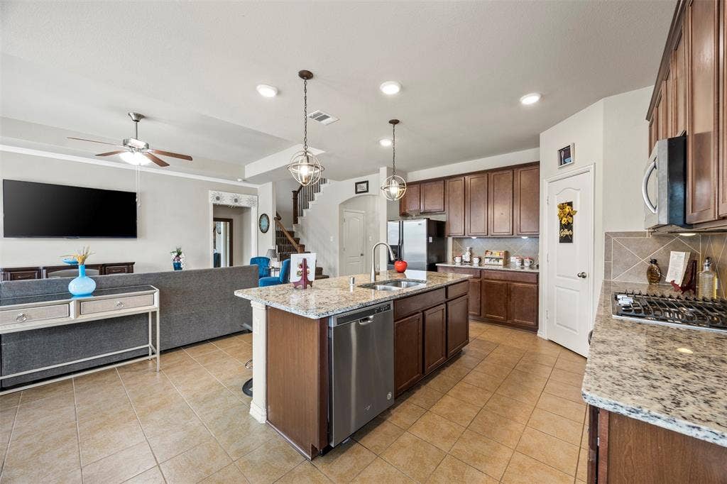 1437 Tanglewood Trail, Northlake, TX 76226 Kitchen island featuring granite countertops, a stainless steel double sink, and pendant lighting