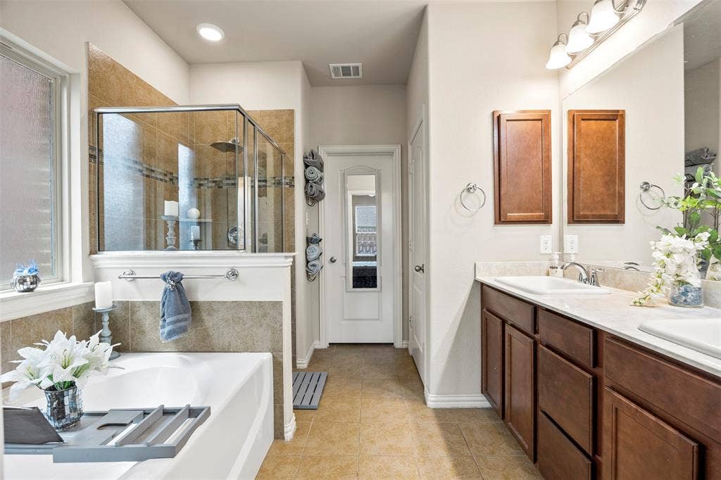 1437 Tanglewood Trail, Northlake, TX 76226 Dual vanity with integrated sinks, framed mirror, and warm wood-finish cabinetry