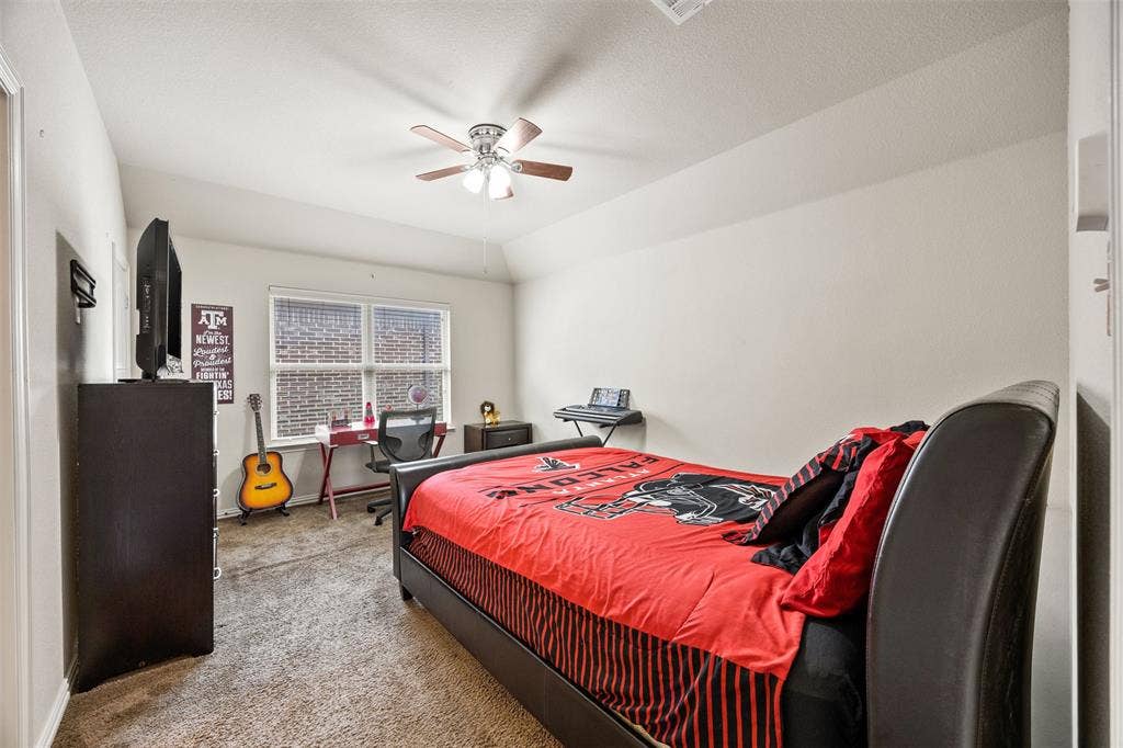 1437 Tanglewood Trail, Northlake, TX 76226 Carpeted room featuring a ceiling fan with light fixture, a window with brick exterior visibility, and a built-in closet