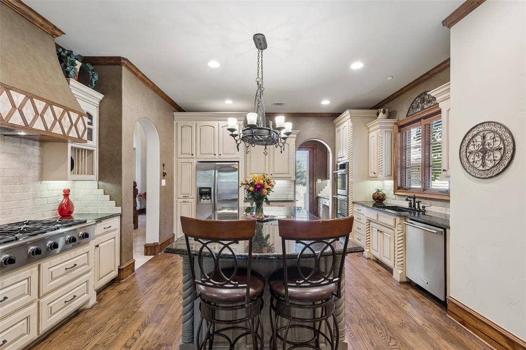 125 Audrey Drive, Keller, TX 76248 Large chef kitchen with gas range, double oven, built in microwave, large pantry, granite countertops and hard wood floors.