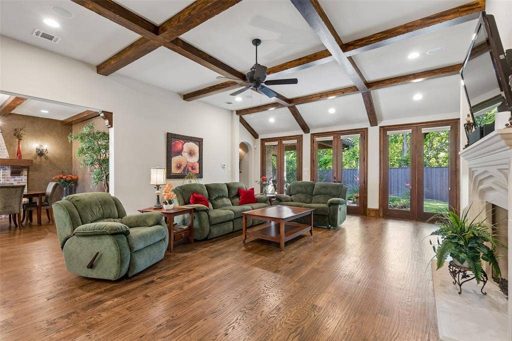 125 Audrey Drive, Keller, TX 76248 Living room with beautiful hardwood floors, Large Masonry Isokern Fireplace (Isokern fireplaces by Earthcore are crafted from pure Icelandic volcanic pumice, delivering unmatched insulation and heat refraction), beautiful glass doors leading out to the backyard, ceiling fan and high celings.