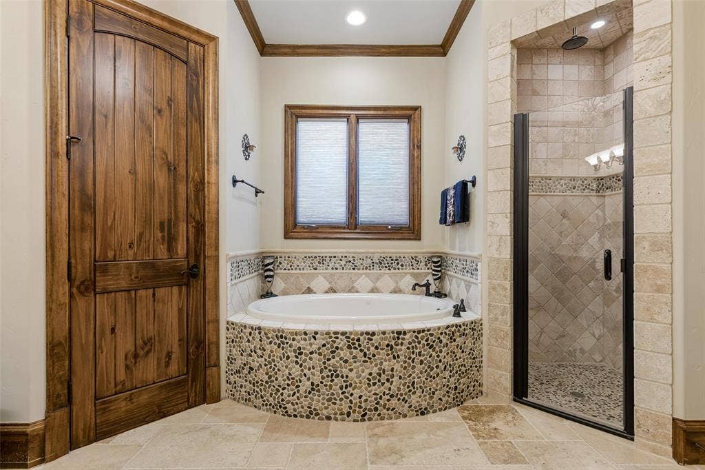 125 Audrey Drive, Keller, TX 76248 Primary bathroom featuring granite countertops, travertine flooring, chandelier, walk in closet, jetted soaking tub, walk in shower and makeup vanity.
